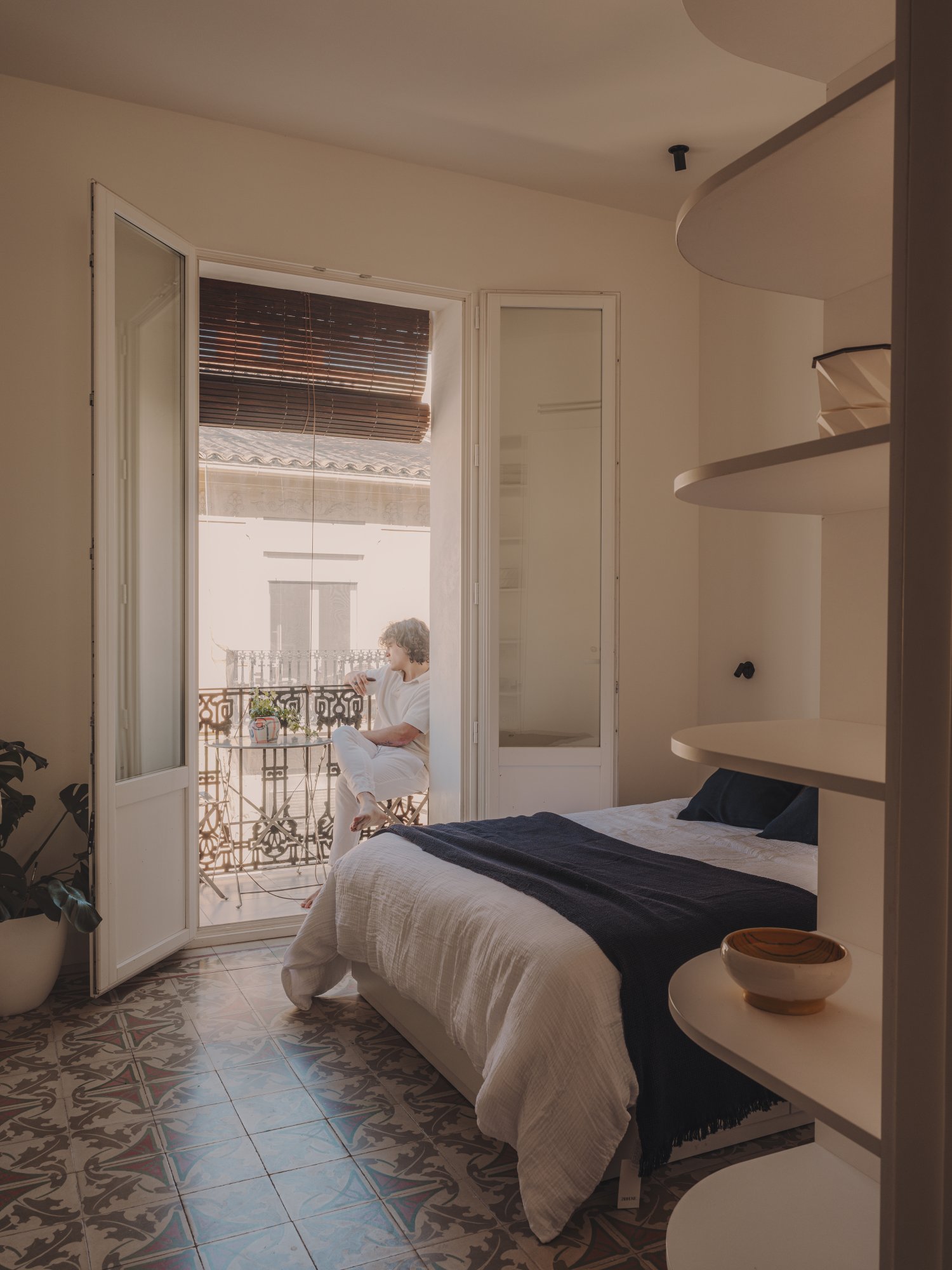 Dormitorio con balcón de forja y suelo hidráulico