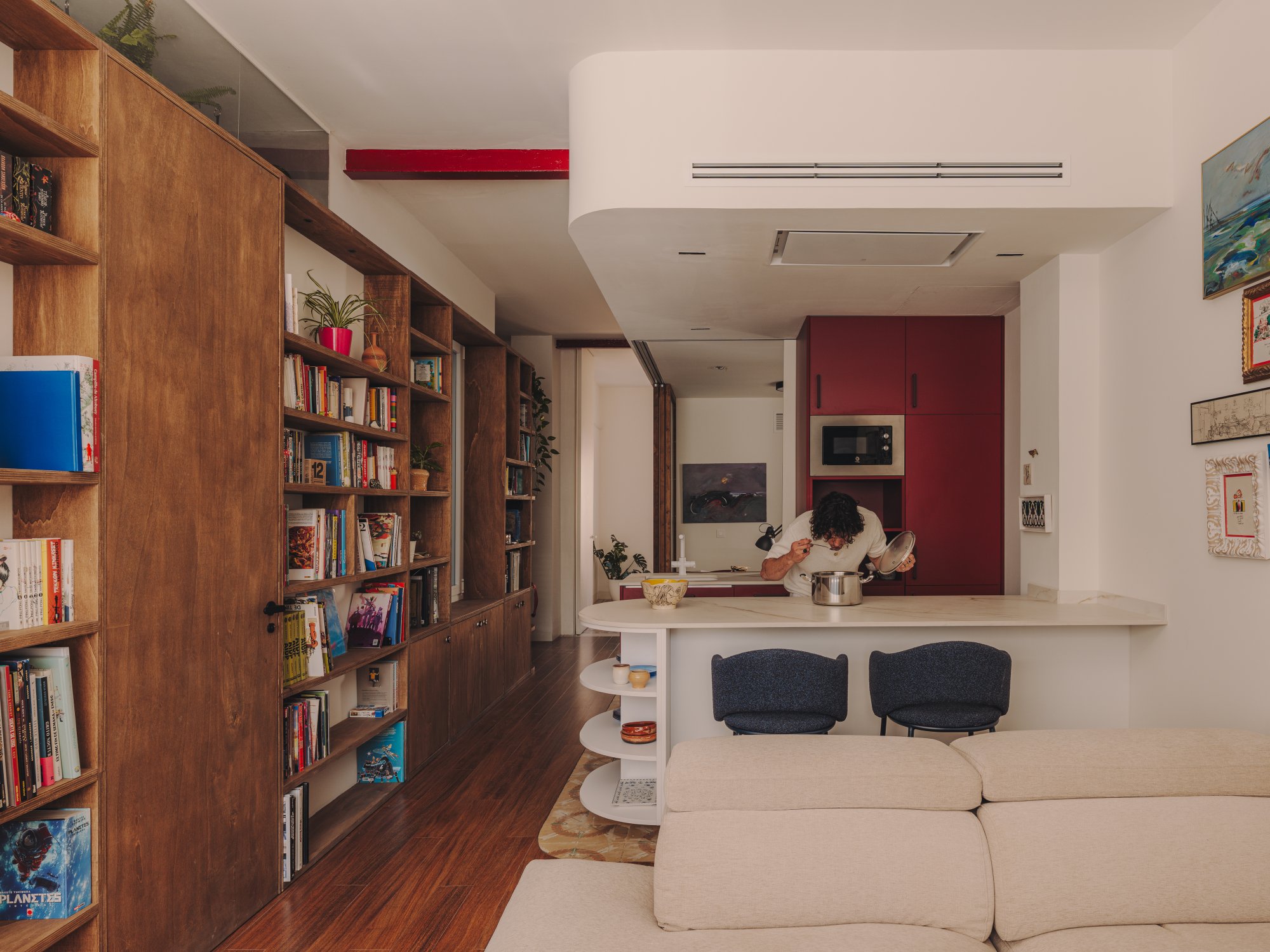 Estantería curva y escultórica que recorre el pasillo de Casa Artista