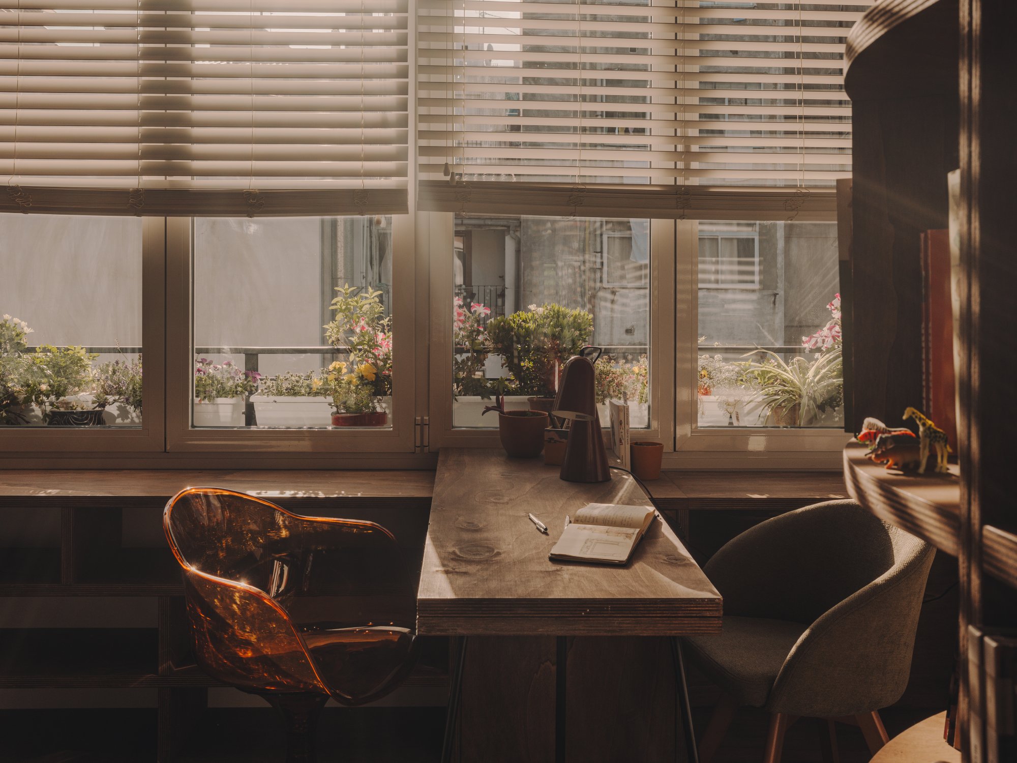 Mesa de trabajo junto a la ventana con plantas en el exterior