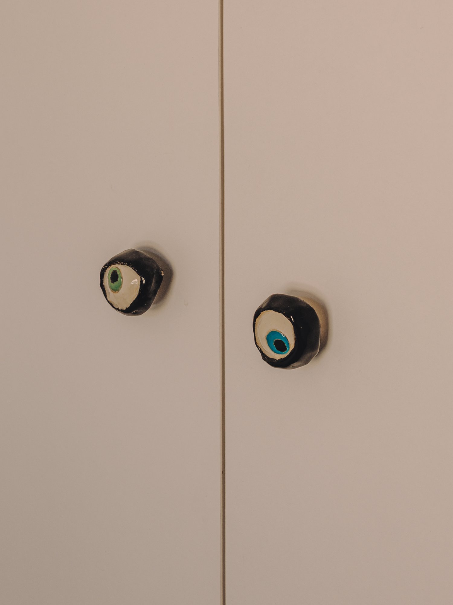 Tiradores cerámicos en forma de ojo en puertas de armario