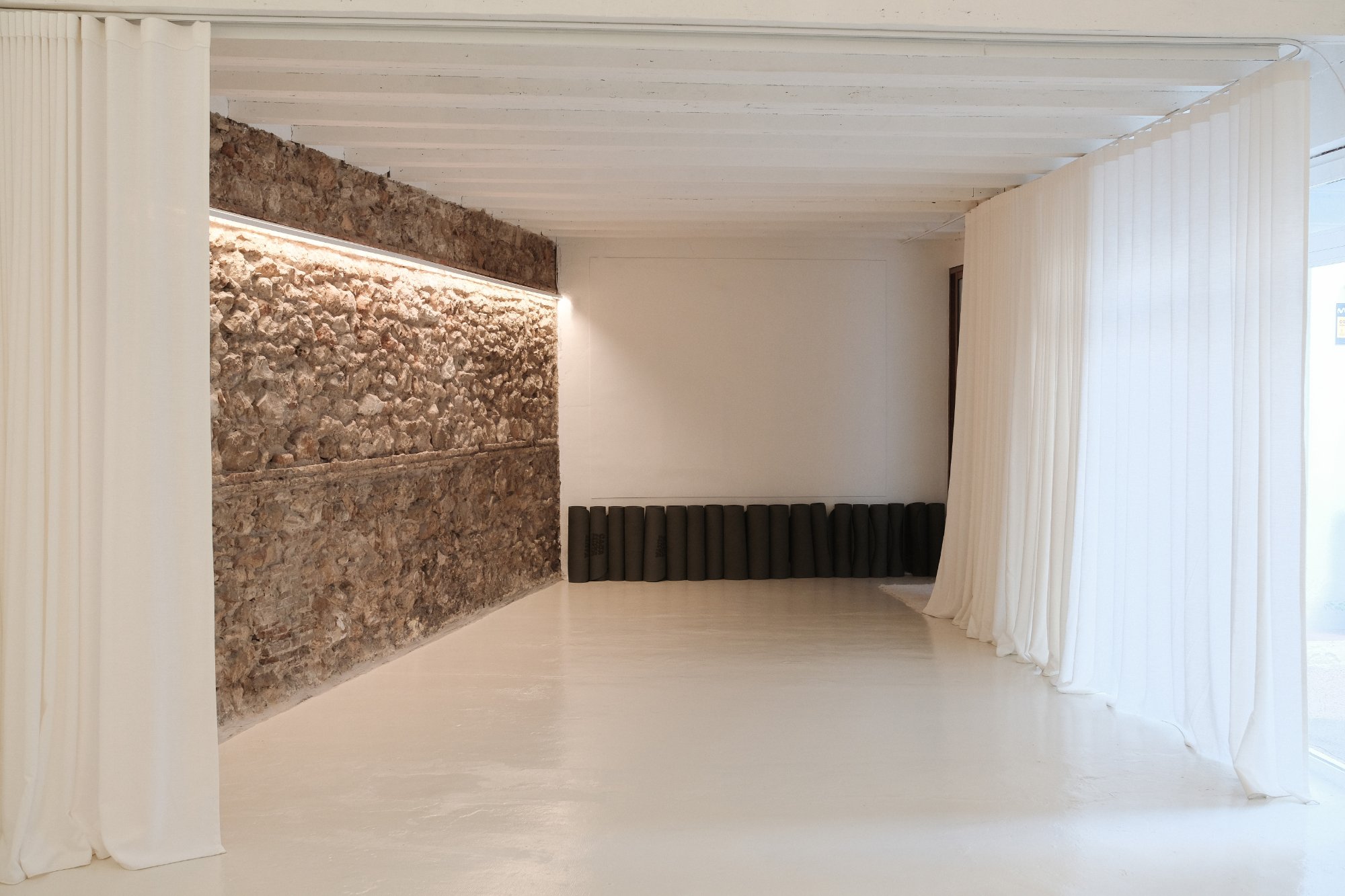 Sala de yoga con muro de piedra