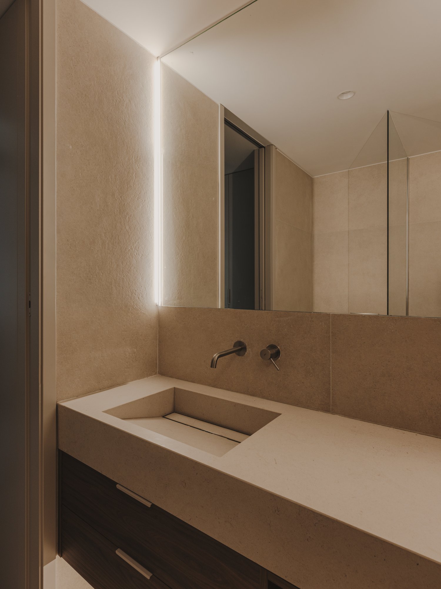 Baño con luz indirecta y lavabo de piedra