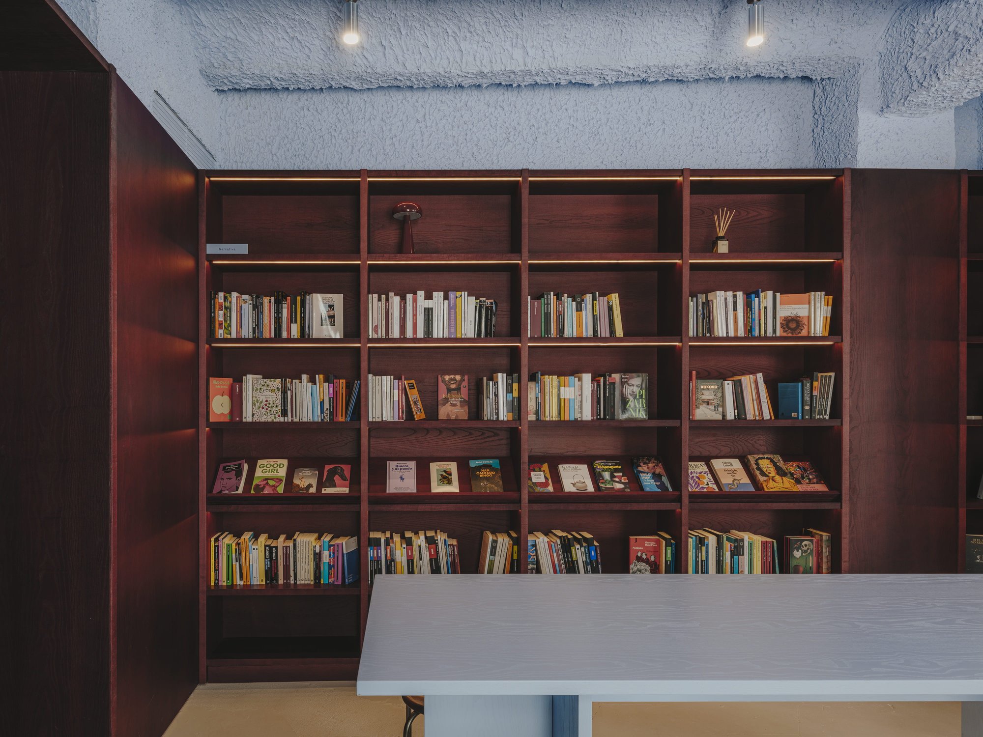 Estantería de libros frente a la barra azul
