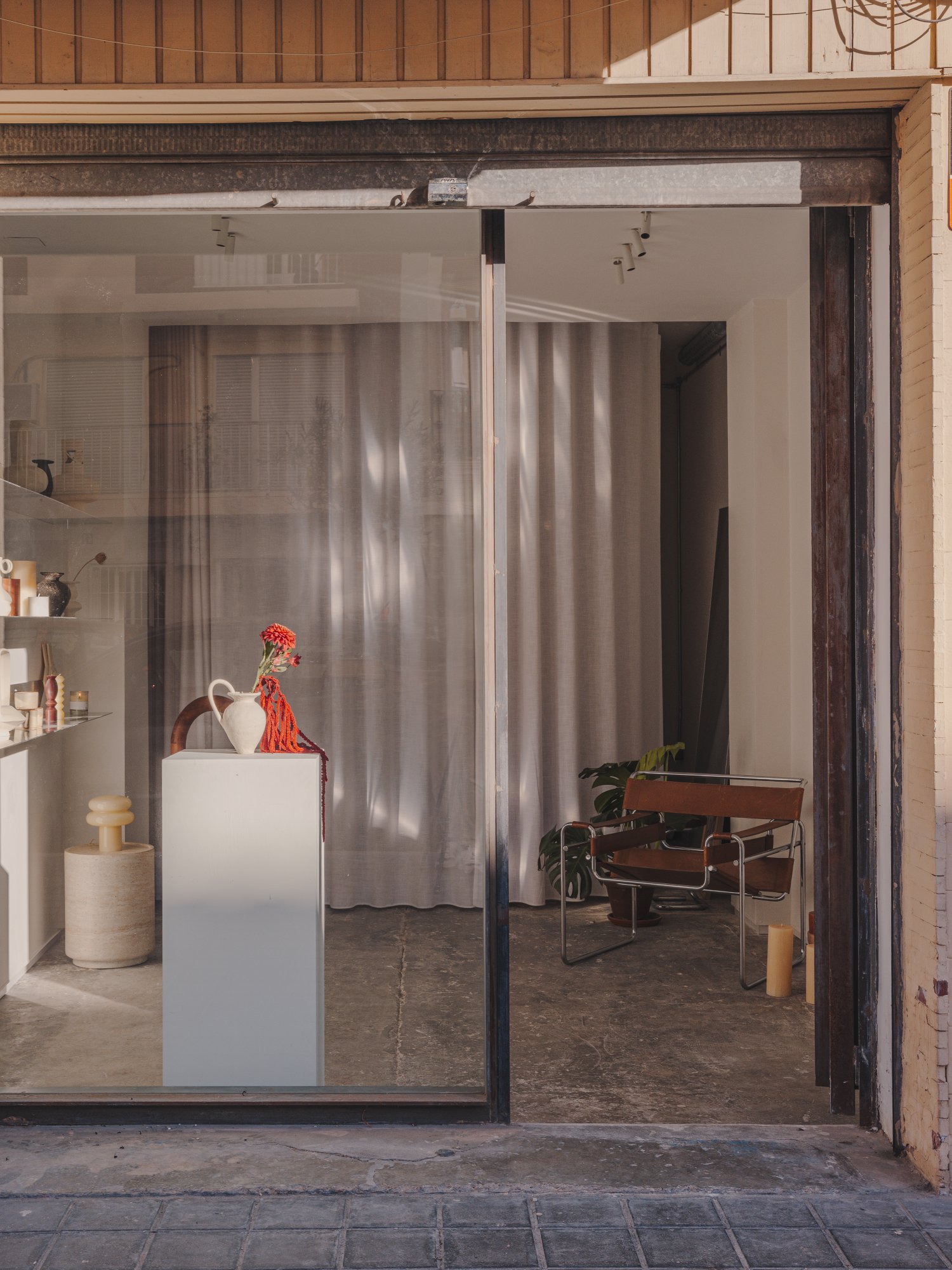 Escaparate con silla Wassily y cortinas ligeras