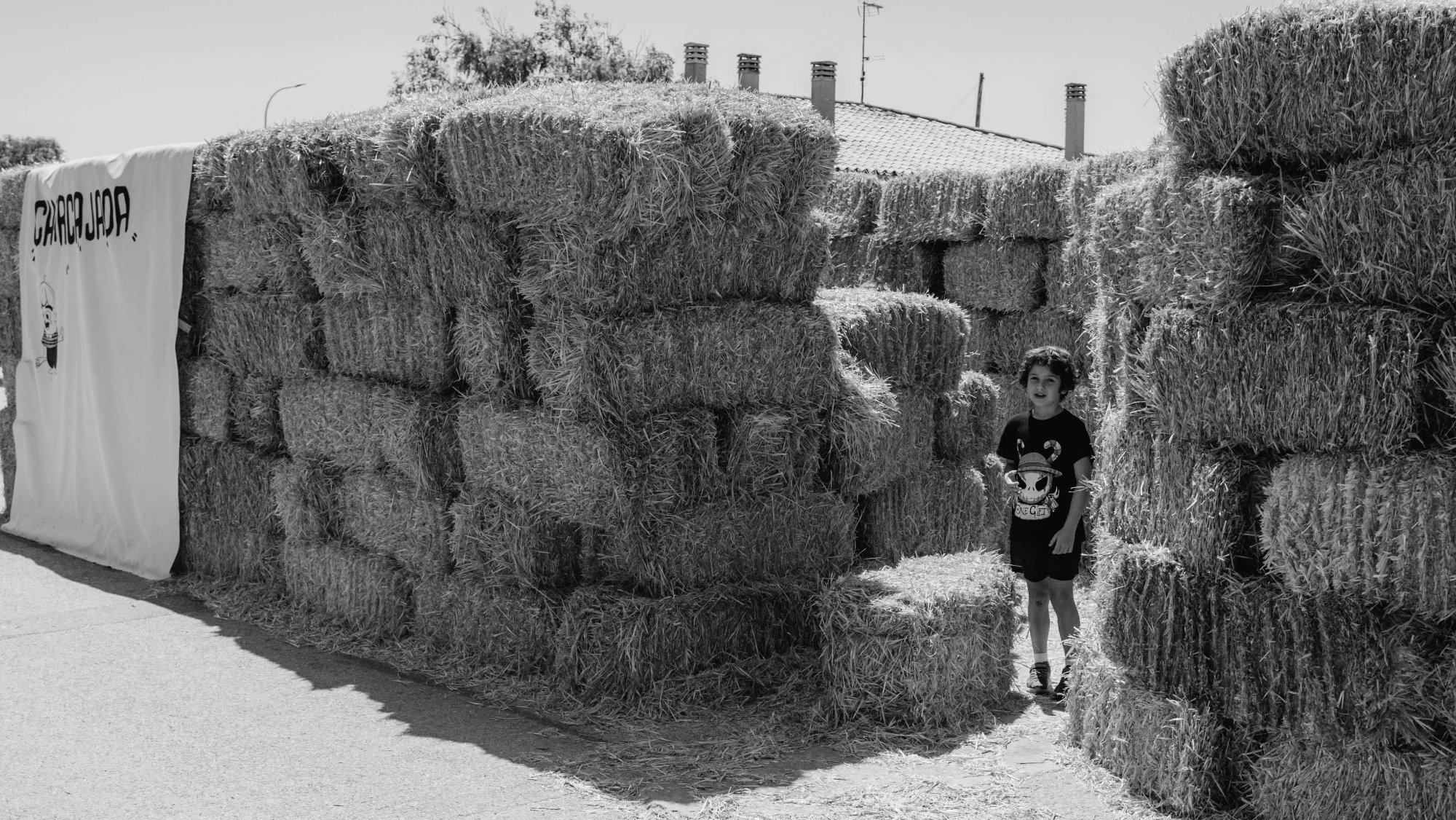 Pacas de paja niño y sábana con logo del festival
